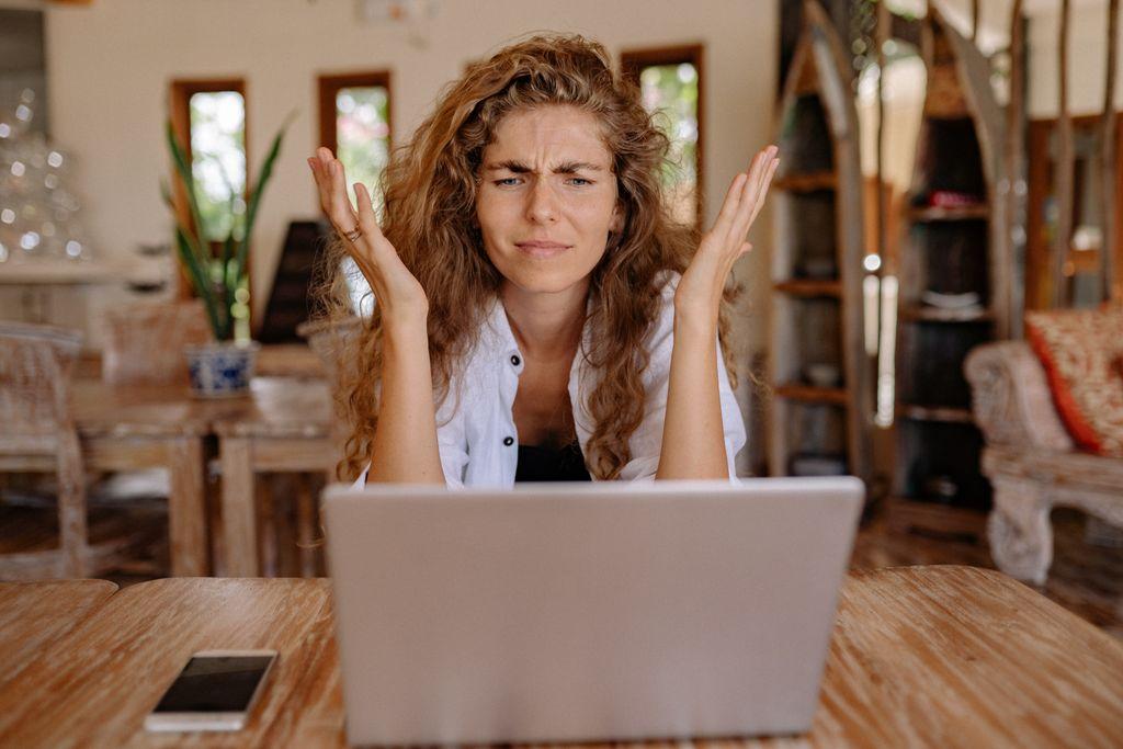 Woman looking frustrated while using a laptop