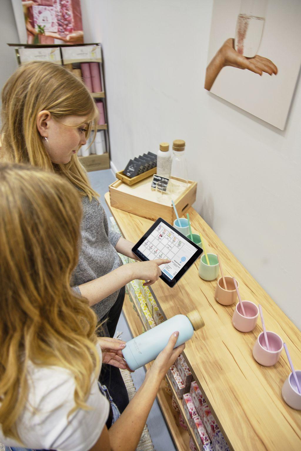 Customers comparing products on a tablet in a store